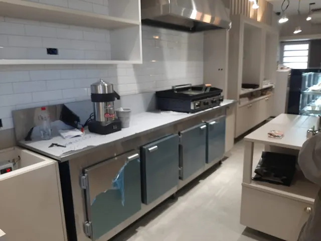 Bancada refrigerada em aço inox com portas, instalada em cozinha comercial