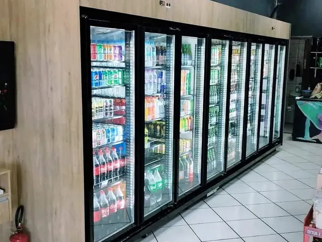 Parede de geladeiras expositoras com portas de vidro e iluminação em LED, com acabamento em madeira